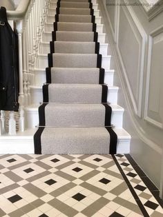 a carpeted staircase with black and white tiles