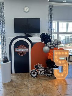 a motorcycle themed birthday party with balloons and neon signs on the front wall, along with an illuminated letter that says 5