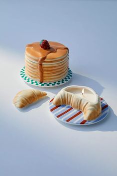 a cake with a candle on it next to some pastries