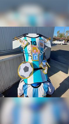 the back end of a blue and white soccer jersey on display in front of a building