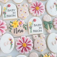 baby in bloom decorated cookies are displayed on a table