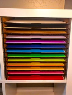 a shelf filled with lots of different colored papers