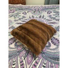 a brown pillow on top of a bed covered in blankets and pillows with an animal print design