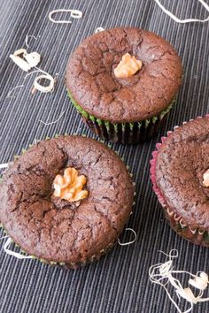 three chocolate cupcakes sitting on top of a table