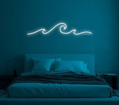 a bed in a room with blue walls and a neon wave on the wall above it