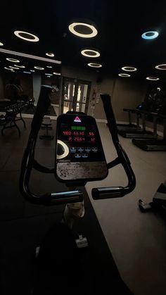 an exercise room with treadmills and lights