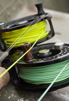 two spools of green and yellow pla on top of a metal object