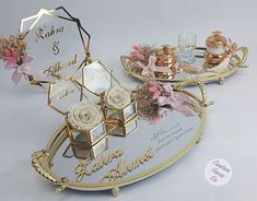 two decorative trays with flowers and perfume bottles on them, both decorated in gold