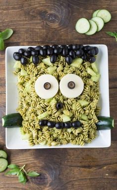 a plate with noodles and vegetables in the shape of a face