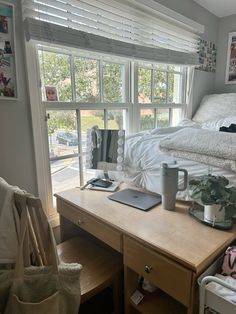 a bed room with a neatly made bed next to a desk and chair in front of a window