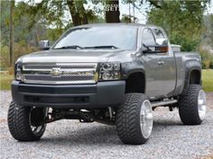 a silver truck parked on top of a gravel road