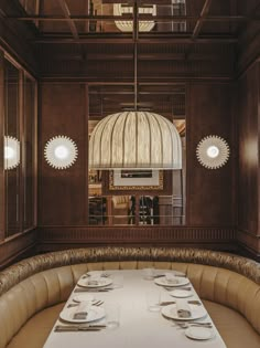 a table with plates and place settings in a room that has wood paneling on the walls