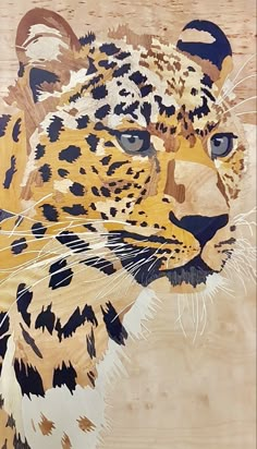 a painting of a leopard's face with blue eyes