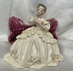 a porcelain figurine of a woman sitting on a chair