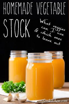 three jars filled with orange juice sitting on top of a table next to garlic and parsley