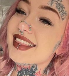 a woman with pink hair and piercings on her nose