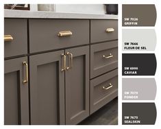 the kitchen cabinets are painted in gray and gold, with brass pulls on each drawer