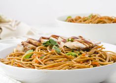 two white bowls filled with noodles and chicken