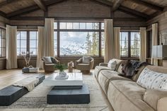 a living room filled with furniture and large windows