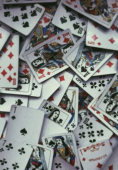 many playing cards are scattered on top of each other