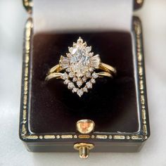 an antique diamond ring sits in a black box