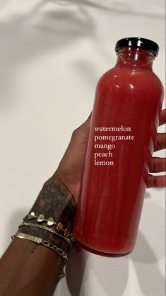 a hand holding a red bottle that says watermelon pomegranate peach lemon