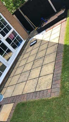 an overhead view of a patio with grass and brick pavers in the foreground