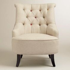 an upholstered chair with buttons on the back and arms is shown in front of a white background