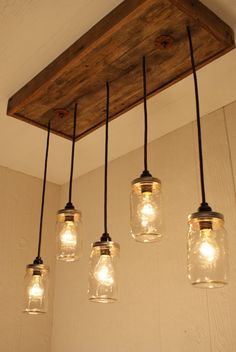 five mason jar lights hanging from a wooden beam