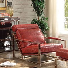 a red leather chair and ottoman in front of a brick wall