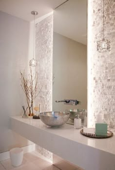 a bathroom sink with two bowls on top of it next to a mirror and lights