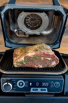 a piece of meat is being cooked on the grill in front of an open oven