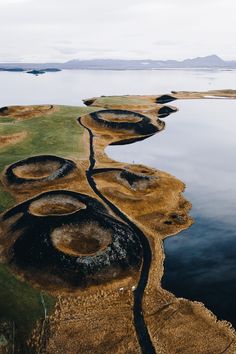 an aerial view of the water and land around it, with mountains in the distance