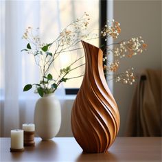 a wooden vase sitting on top of a table next to two candles and some flowers