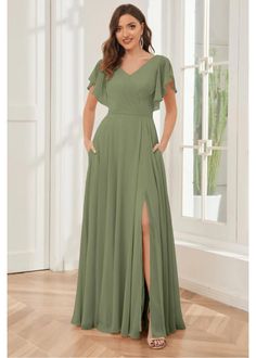 a woman in a long green dress posing for the camera with her hands on her hips