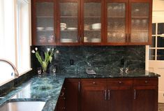 a kitchen with marble counter tops and wooden cabinets