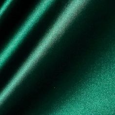 a close up view of a green fabric textured with metallic flecks and folds