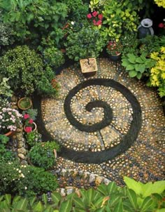 an aerial view of a garden with rocks and plants in the center, surrounded by greenery