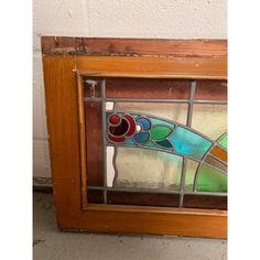 an old stained glass window with wooden frame