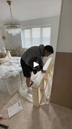 a man standing on top of a bed in a bedroom