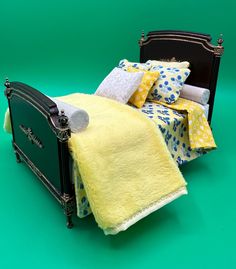 a black bed with yellow and blue pillows on it's headboard, against a green background