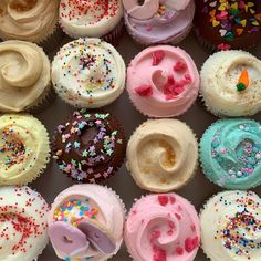 a box filled with lots of different colored cupcakes