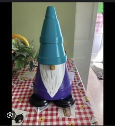 a blue and purple gnome hat sitting on top of a red checkered table cloth