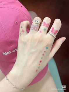 a woman's hand with tattoos on it and a baseball cap in the background