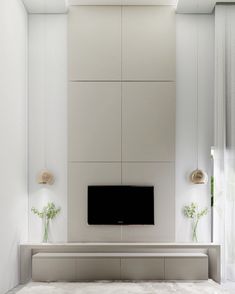 a tv mounted on the wall in a living room with white walls and flooring