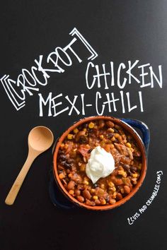 a bowl filled with chili and sour cream on top of a chalkboard that says texas chicken mexican chili