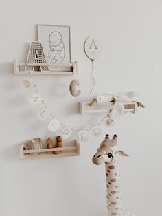 a toy giraffe standing next to a wooden shelf