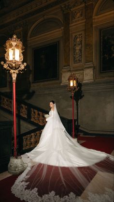 a woman in a wedding dress standing next to a light pole and lamp on the ground