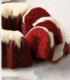 a red velvet bundt cake with white icing on a plate next to another bundt cake