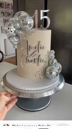 a white cake with silver decorations and the number five on it's side, sitting on a table